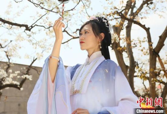 圖為蘭州青年身穿漢服在百年梨園賞景?！「哒?攝