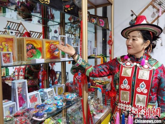 圖為身著民族服飾的隴原巧手展示手工藝品。(資料圖) 徐雪 攝