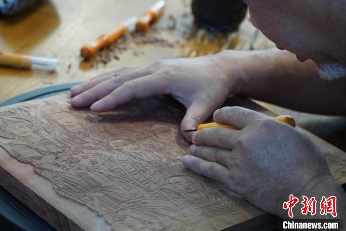 圖為徐晉林湊近木板，近距離制作雕版畫?！【琶赖┰?　攝