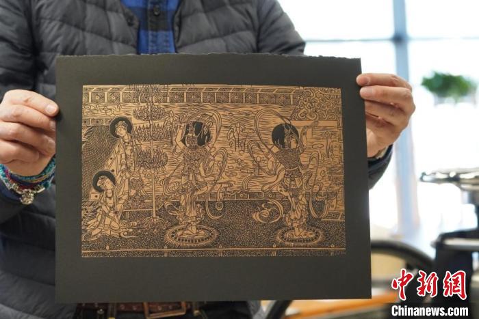 圖為手工書藝人展示敦煌雕版壁畫印刷品?！【琶赖┰?　攝