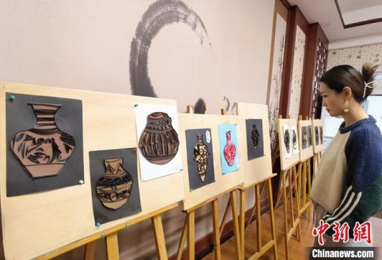 圖為學(xué)生用衍紙材料制作的彩陶紋飾?！⒂裉?攝