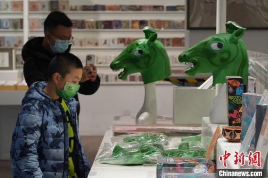 圖為“神馬來了”銅奔馬頭套吸引參觀者駐足?！【琶赖┰?攝