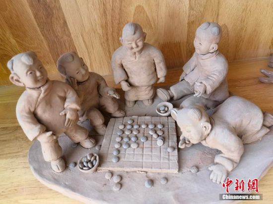 圖為泥塑作品展現(xiàn)下棋場景。 劉玉桃 攝