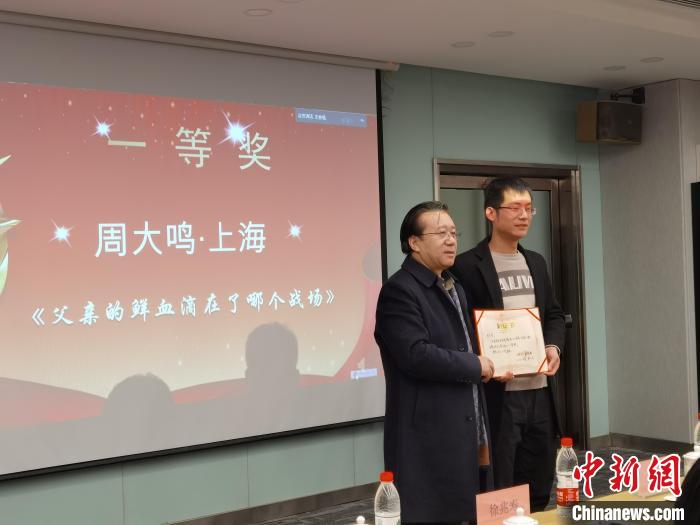 圖為作家、西北師范大學新聞與傳媒學院院長徐兆壽頒發(fā)一等獎證書，代領獎者上臺領獎?！钅?攝