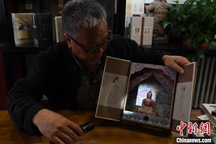 圖為讀者出版集團讀者晉林工作室獨立出品人徐晉林，展示互動性強的敦煌題材手工書。(資料圖) 楊艷敏 攝