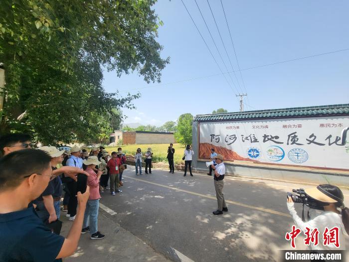 圖為中國地質(zhì)大學(xué)(北京)教授張緒教介紹村落情況。　胡友軍 攝