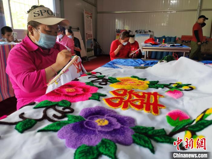 圖為婦女制作青繡?！?zhí)砀?攝