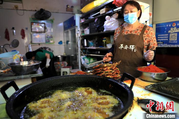 圖為平安驛·河湟民俗文化體驗地內的商戶炸干板魚?！⊙Φ?攝