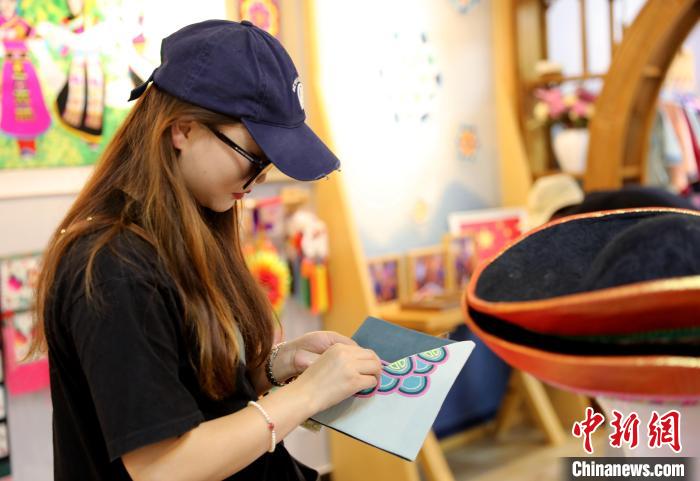 圖為民眾體驗(yàn)國家級非遺項目盤繡技藝?！⊙Φ?攝