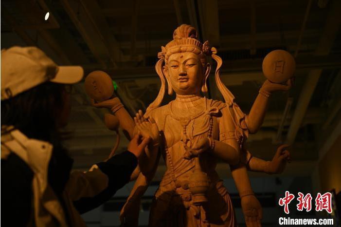 圖為季茂杰觀察自己創(chuàng)作的敦煌木雕。李亞龍 攝</p>
<p>