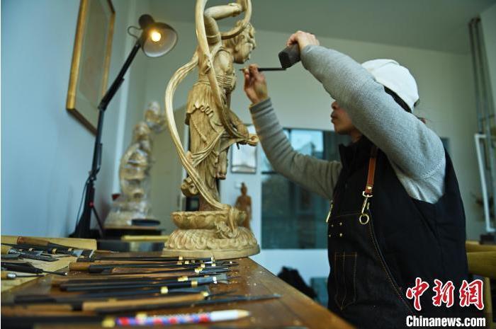 圖為季茂杰進(jìn)行敦煌元素的木雕創(chuàng)作。李亞龍 攝</p>
<p>