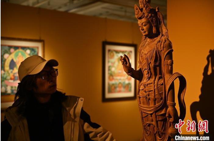 圖為季茂杰觀察自己創(chuàng)作的敦煌木雕。李亞龍 攝</p>
<p>