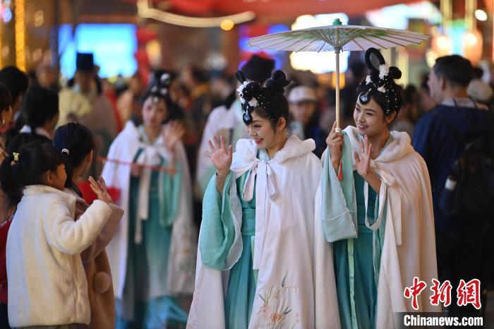 圖為街區(qū)人員著傳統(tǒng)服飾與游人互動(dòng)。李亞龍 攝</p><p>