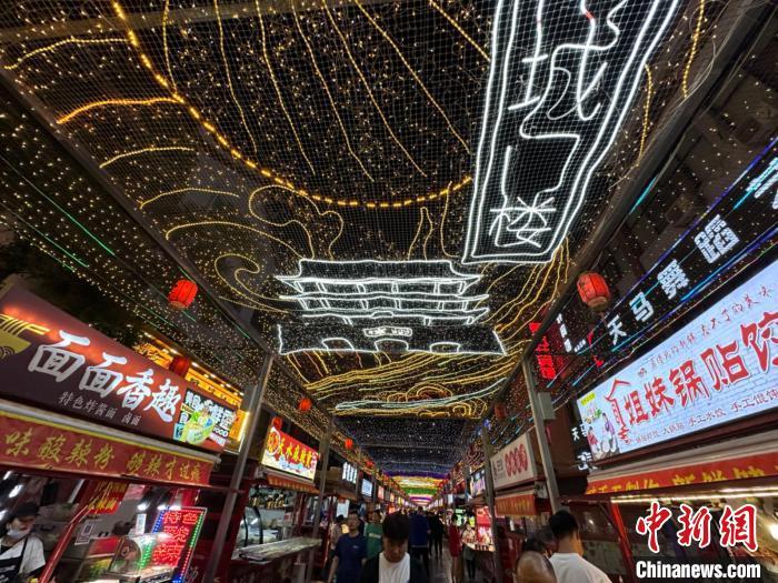 圖為明清街夜市燈光點(diǎn)亮具有武威文化元素的“涼州古城門”彩燈?！〈魑牟?攝</p><p>