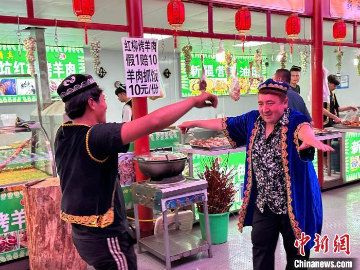 圖為餐飲經(jīng)營者在“西涼不夜城”跳起舞蹈引客。　戴文昌 攝</p><p>