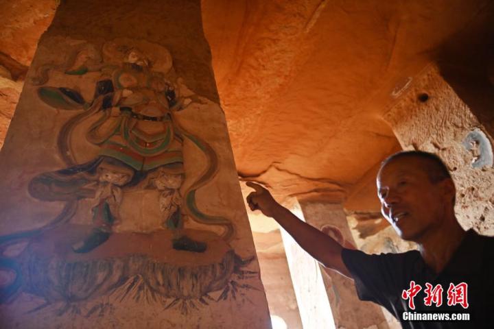 7月15日，甘肅省平?jīng)鍪袥艽h百里石窟長廊羅漢洞石窟內(nèi)，該窟文保員郭建平介紹窟內(nèi)石刻彩繪壁畫。郭建平家中三代人曾自發(fā)保護羅漢洞石窟。羅漢洞石窟遺存40余個窟龕，以北魏至清代風格為主。中新社記者 李亞龍 攝</p>
<p>