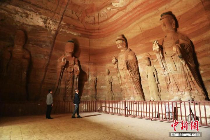 7月15日，游人參觀甘肅省平?jīng)鍪袥艽h百里石窟長廊中的南石窟寺1號窟。百里石窟長廊位于涇川縣境內(nèi)，由512個石窟、5眼窟中石井組成，現(xiàn)存王母宮石窟、鳳凰山石窟、南石窟寺、丈八寺石窟、羅漢洞石窟、太山寺石窟等規(guī)模較大的石窟群，還有數(shù)量眾多的小石窟群。南石窟寺開鑿于北魏永平三年，其中1號窟屬于大型七佛窟，七佛高達6米。中新社記者 李亞龍 攝