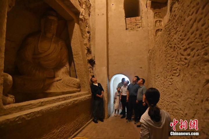 7月15日，游人參觀甘肅省平?jīng)鍪袥艽h百里石窟長廊中的王母宮石窟。百里石窟長廊位于涇川縣境內(nèi)，由512個石窟、5眼窟中石井組成，現(xiàn)存王母宮石窟、鳳凰山石窟、南石窟寺、丈八寺石窟、羅漢洞石窟、太山寺石窟等規(guī)模較大的石窟群，還有數(shù)量眾多的小石窟群。王母宮石窟又名千佛洞，該窟設(shè)計宏大，造像生動，窟內(nèi)擁有造像數(shù)百尊，是較為珍貴的佛教文化歷史遺存。中新社記者 李亞龍 攝</p>
<p>