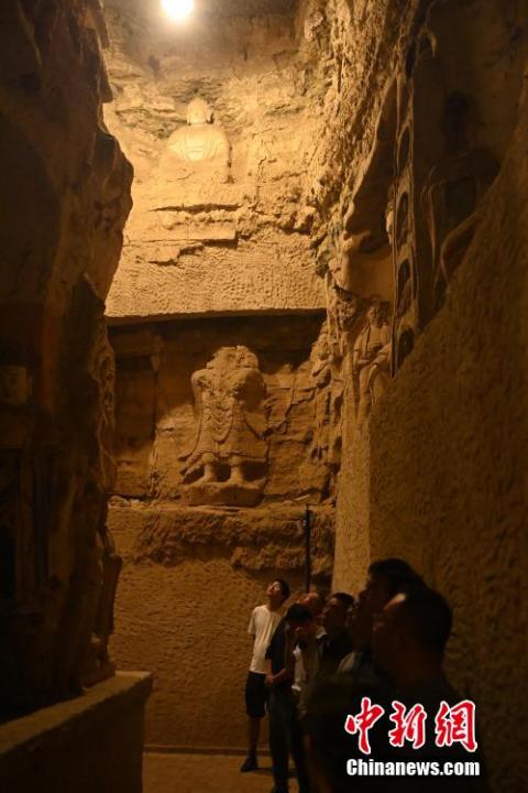 7月15日，游人參觀甘肅省平?jīng)鍪袥艽h百里石窟長廊中的王母宮石窟。百里石窟長廊位于涇川縣境內(nèi)，由512個石窟、5眼窟中石井組成，現(xiàn)存王母宮石窟、鳳凰山石窟、南石窟寺、丈八寺石窟、羅漢洞石窟、太山寺石窟等規(guī)模較大的石窟群，還有數(shù)量眾多的小石窟群。王母宮石窟又名千佛洞，該窟設(shè)計宏大，造像生動，窟內(nèi)擁有造像數(shù)百尊，是較為珍貴的佛教文化遺存。中新社記者 李亞龍 攝</p>
<p>
