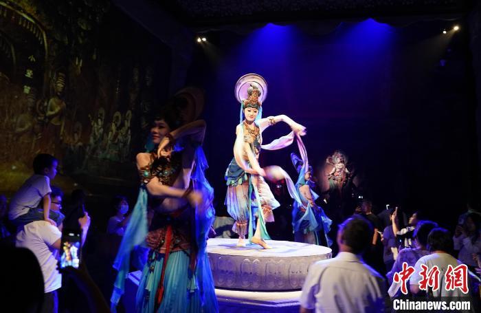 《樂動(dòng)敦煌》是全球首部洞窟式沉浸體驗(yàn)劇，利用真人與數(shù)字影像虛實(shí)交換實(shí)現(xiàn)沉浸式體驗(yàn)。圖為2023年8月28日晚，《樂動(dòng)敦煌》演出。(資料圖)中新社記者 毛建軍 攝