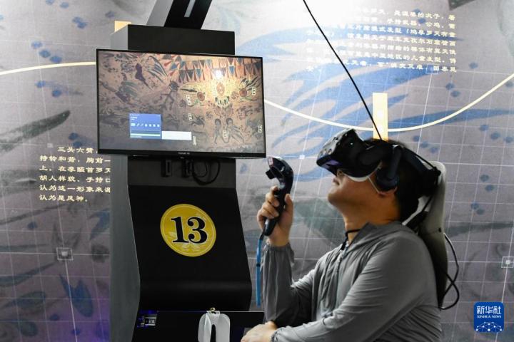 7月22日，游客借助VR設(shè)備沉浸式游覽莫高窟第285窟虛擬場(chǎng)景。新華社記者 郎兵兵 攝